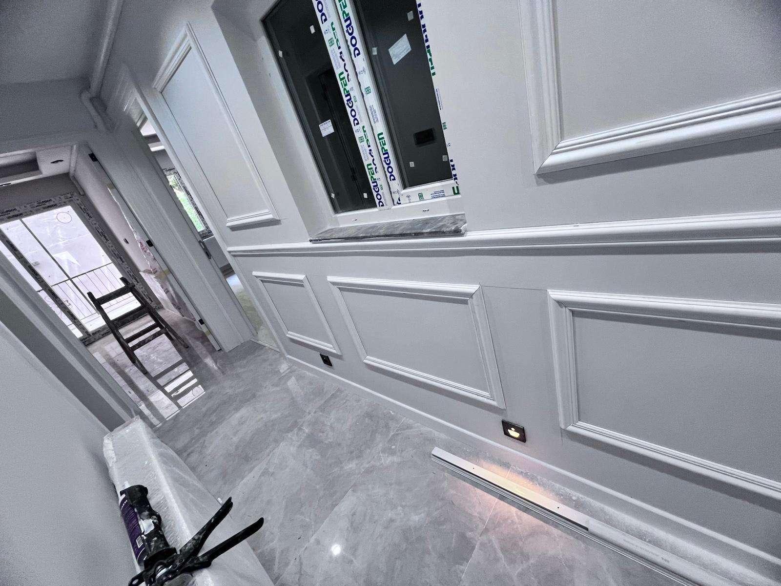 Boyalı ahşap süpürgelik ve panel kaplamalı koridor